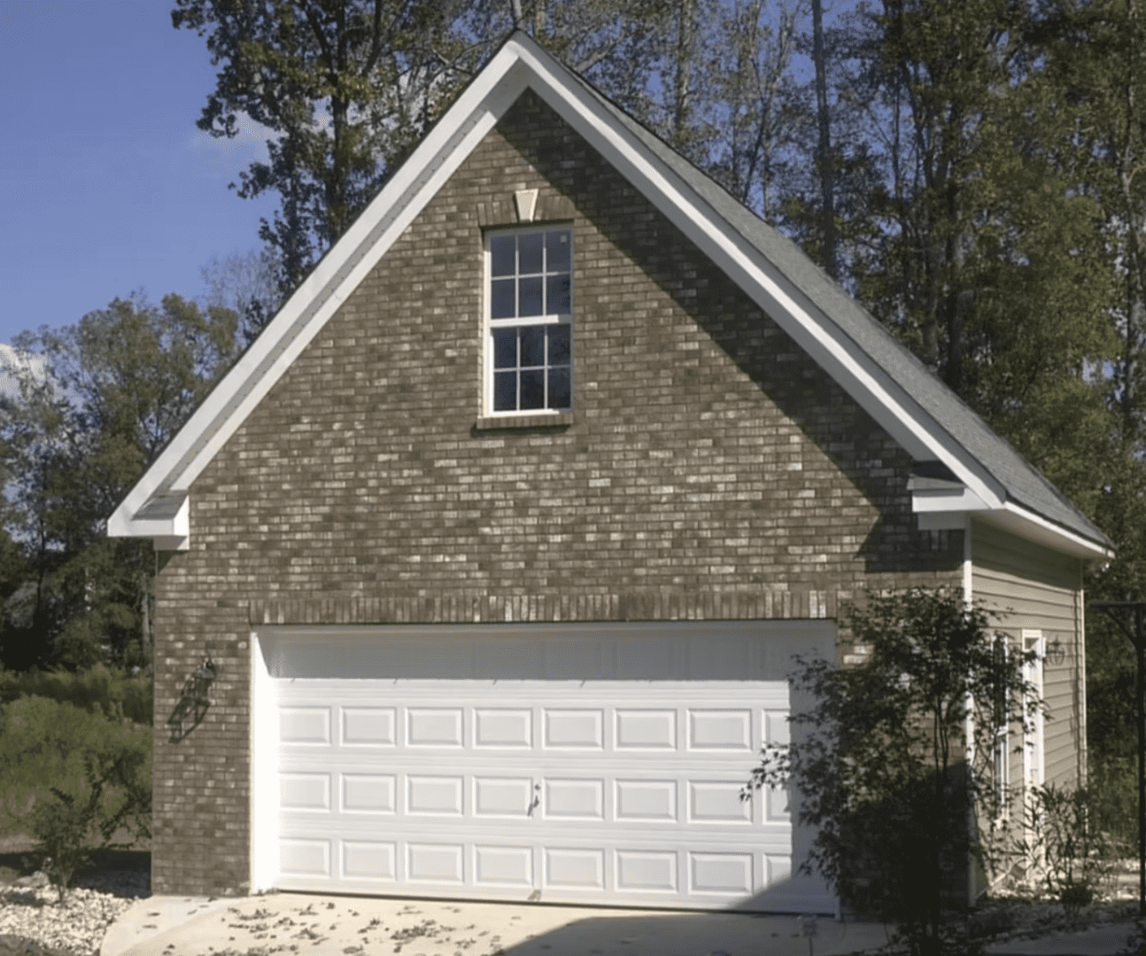 Custom brick and siding detached garage with double garage door